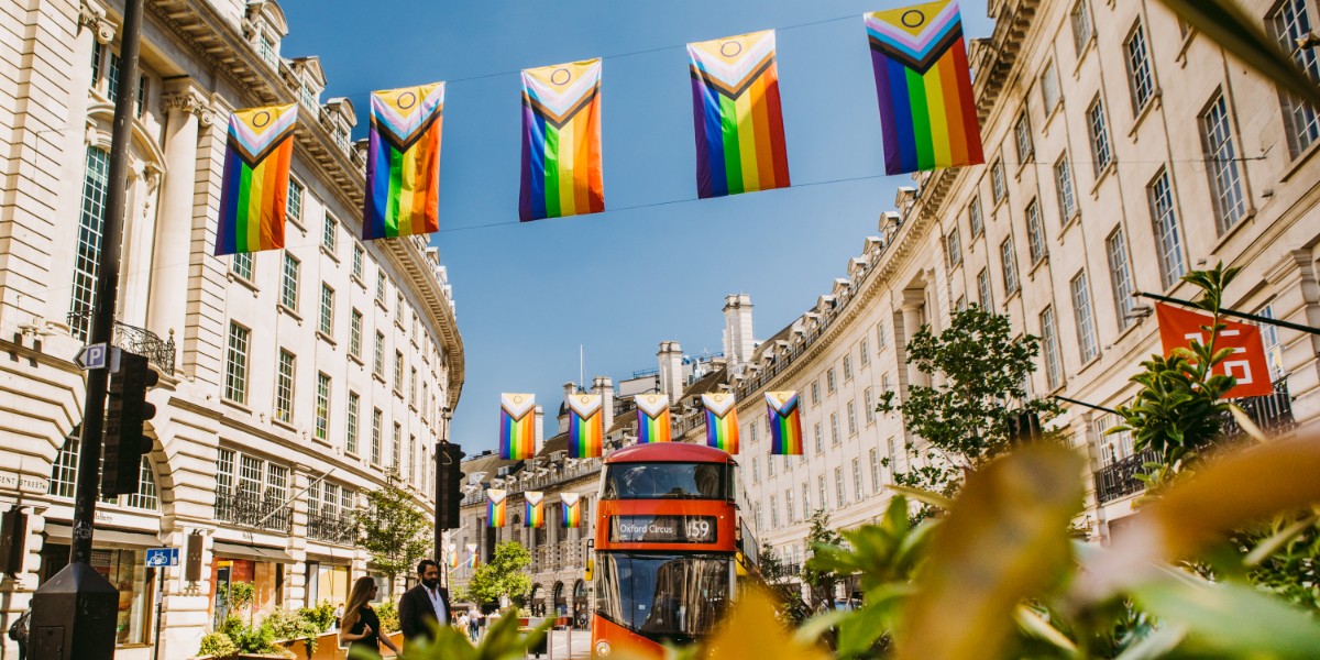 Intersex-Inclusive Pride flags hang about a street with a bus